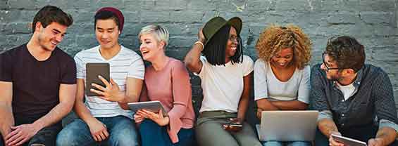 ragazze e ragazzi seduti con laptop e tablet