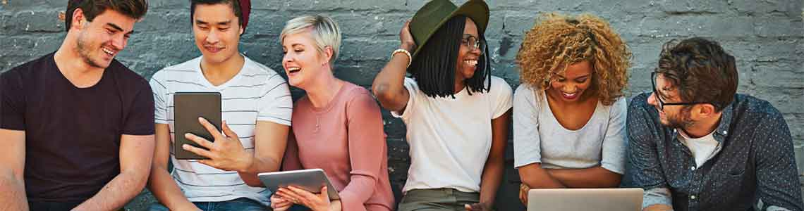 ragazze e ragazzi seduti con laptop e tablet